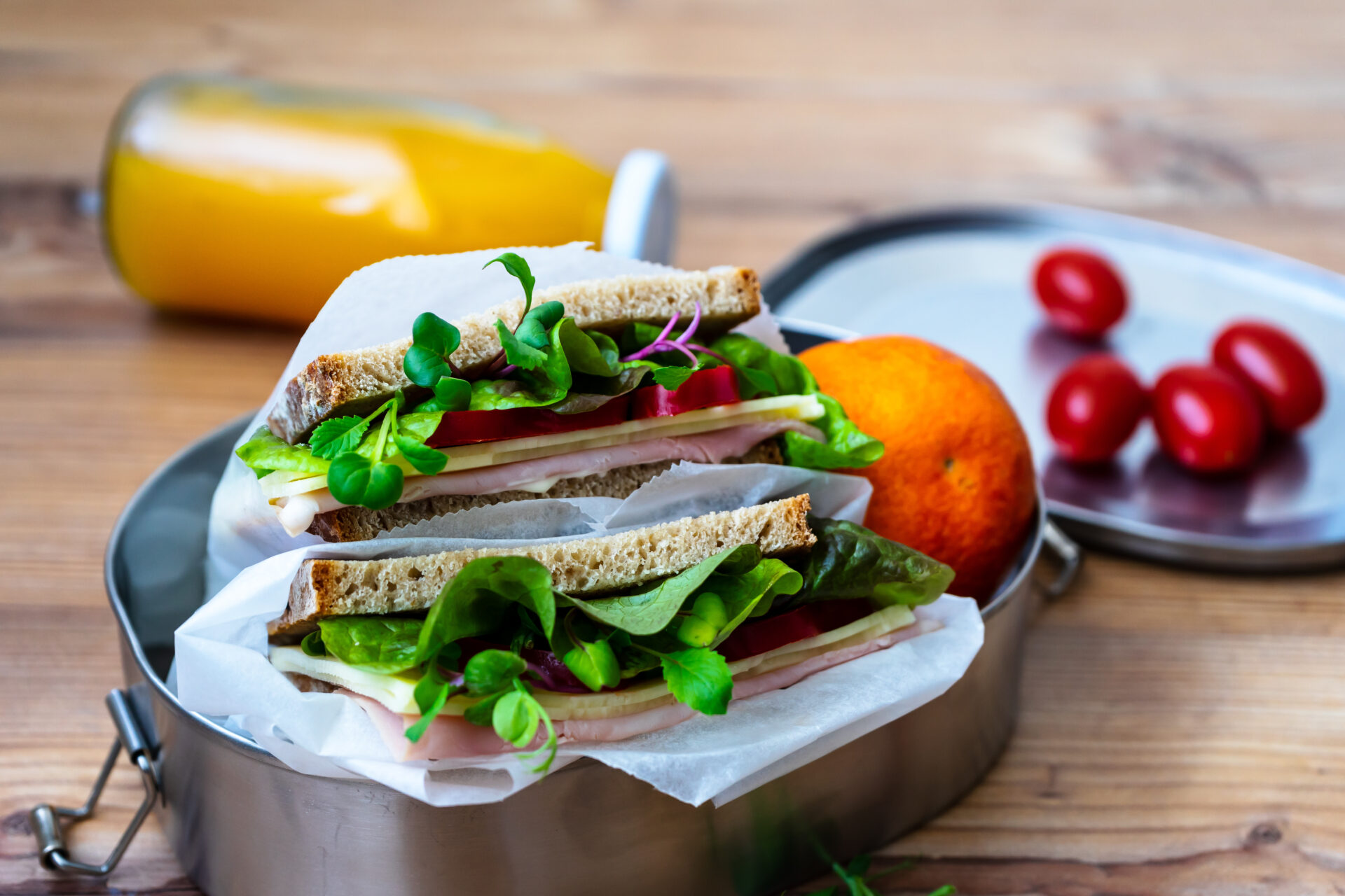Zwei Sandwich mit Salat, Schinken und Käse in einer Blechdose