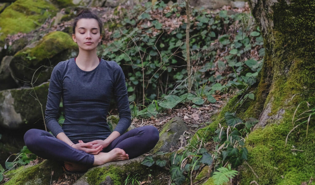 Frau meditiert an einem Kraftort