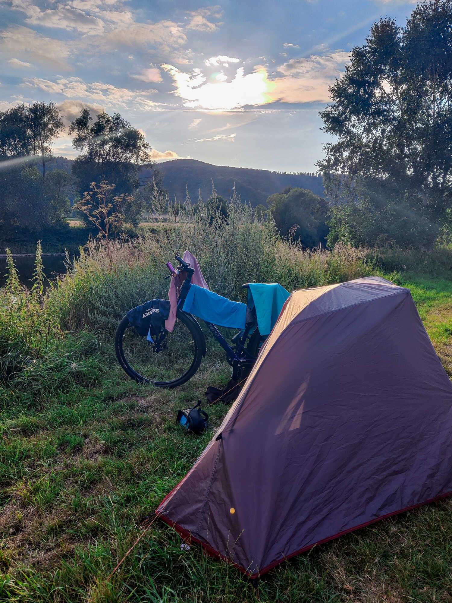 Radreisen: Zelt und Fahrrad im Abendlicht